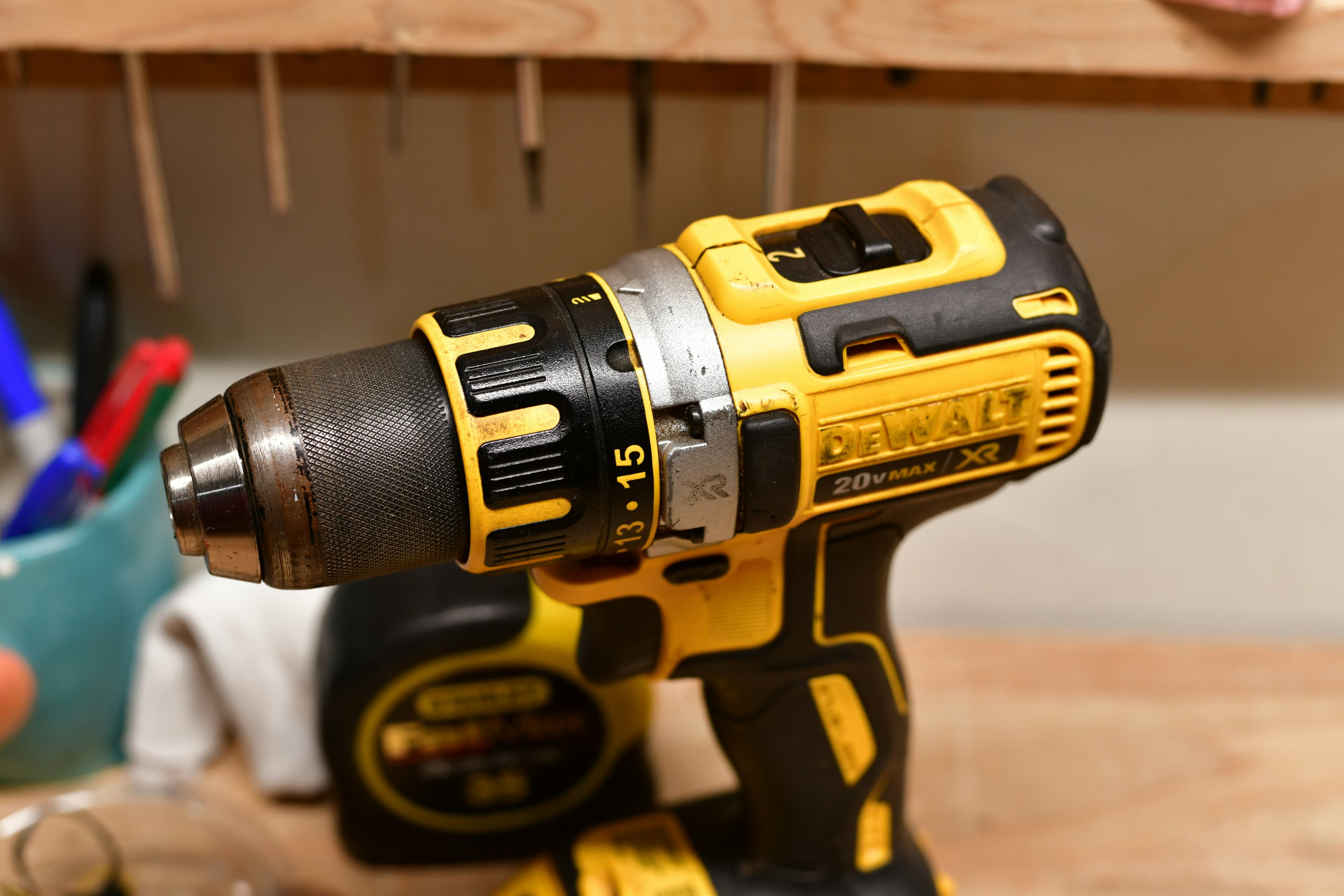 Yellow and black DeWalt cordless drill resting on a wooden workbench.